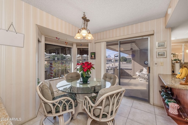 dining area featuring a chandelier, a textured ceiling, and light tile patterned flooring