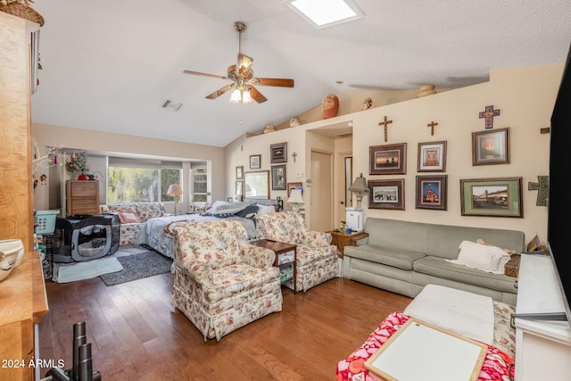 living room featuring hardwood / wood-style flooring, vaulted ceiling, and ceiling fan