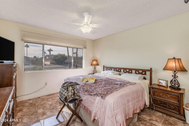 bedroom featuring ceiling fan and a textured ceiling