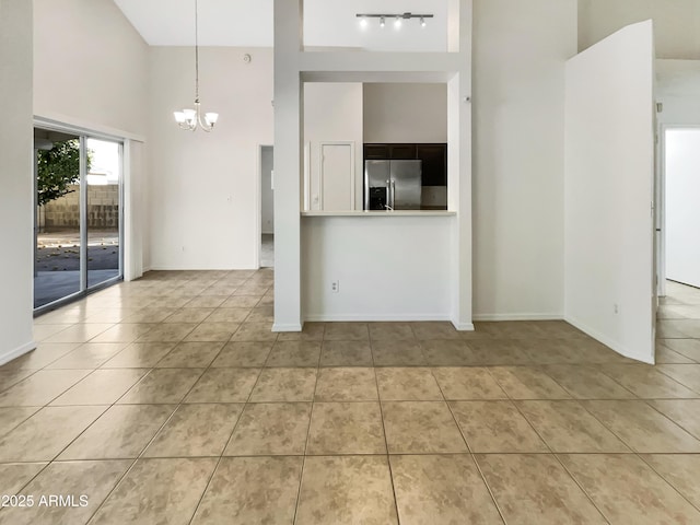 10242 N 66th Ave, Glendale, AZ 85302 - unfurnished living room featuring a towering ceiling, a chandelier, tile patterned floors, and baseboards