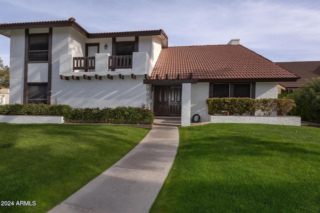 mediterranean / spanish house with a front yard and a balcony