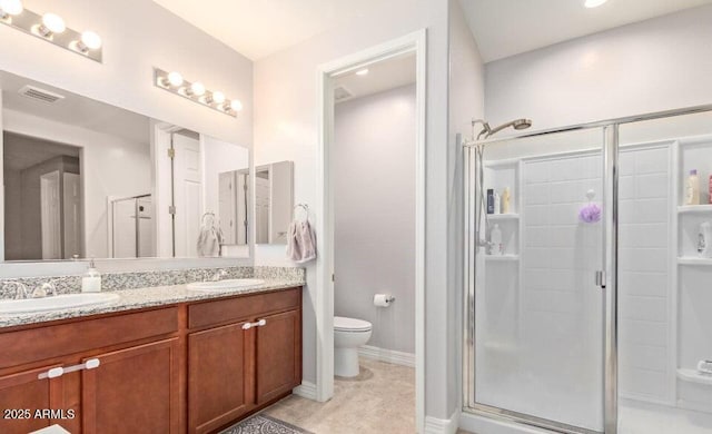 bathroom featuring tile patterned flooring, toilet, a shower with door, and vanity