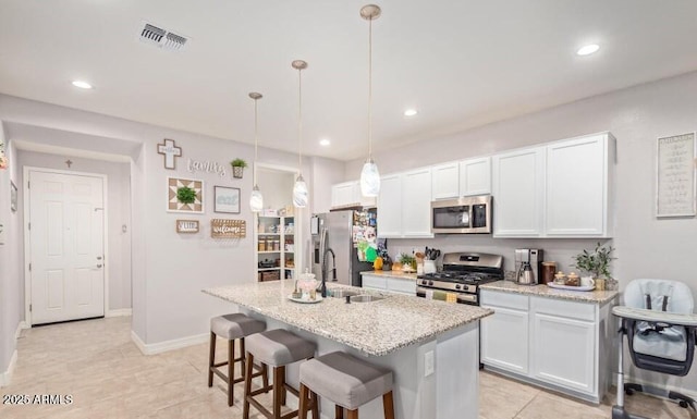 kitchen with decorative light fixtures, sink, white cabinetry, and stainless steel appliances