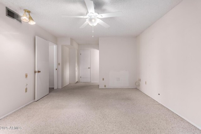 unfurnished room featuring visible vents, a textured ceiling, ceiling fan, and carpet flooring