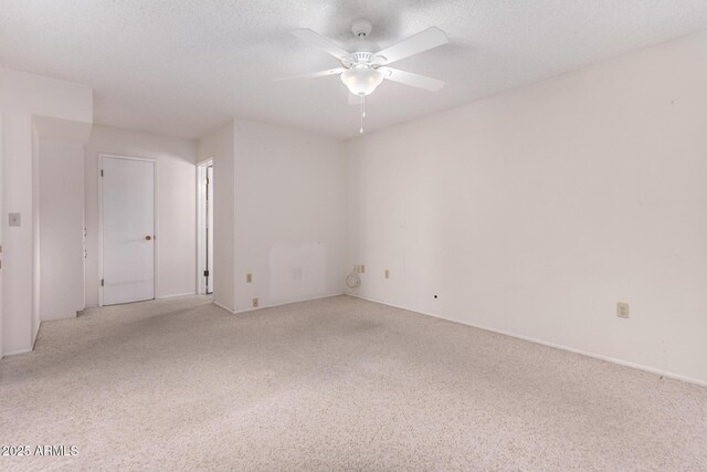 spare room with a ceiling fan, carpet, and a textured ceiling