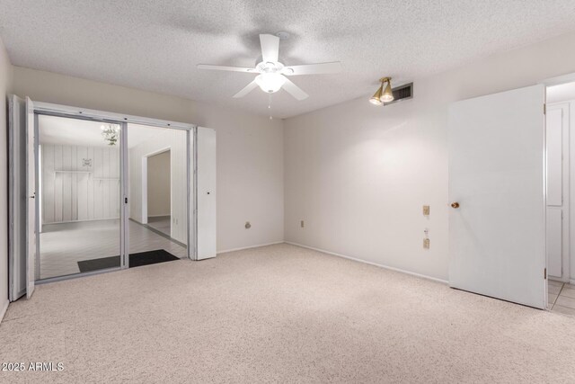 unfurnished bedroom with light colored carpet, a ceiling fan, and a textured ceiling