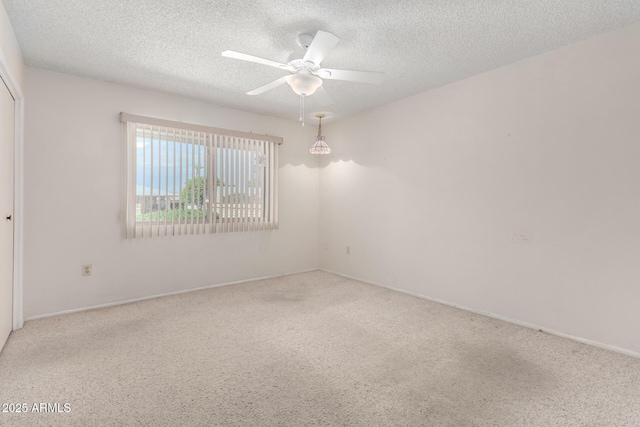 carpeted empty room featuring a textured ceiling and a ceiling fan