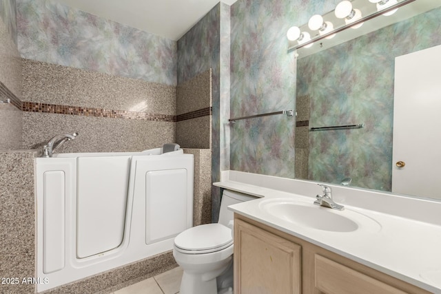 bathroom with vanity, tile patterned floors, toilet, and a washtub