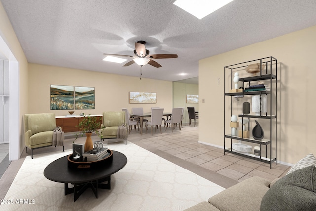 living area with tile patterned flooring, a textured ceiling, and ceiling fan