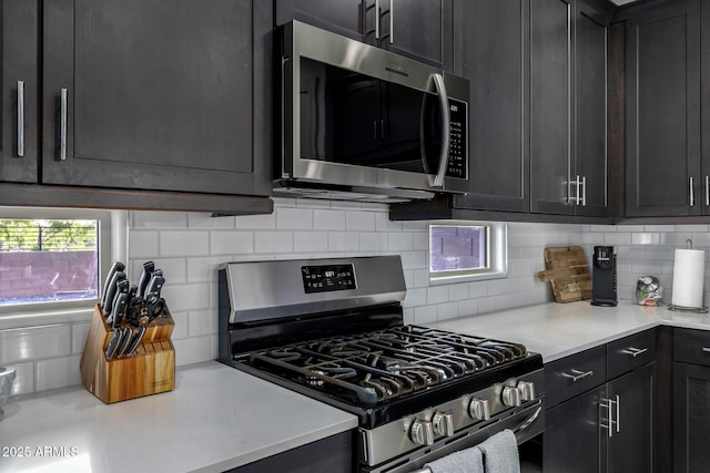 4352 N 91st Gln, Phoenix, AZ 85037 - kitchen with appliances with stainless steel finishes, light countertops, tasteful backsplash, and dark cabinetry