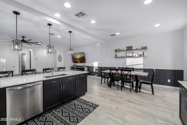 4352 N 91st Gln, Phoenix, AZ 85037 - kitchen featuring dishwasher, a sink, light countertops, a wainscoted wall, and open floor plan