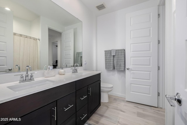 4352 N 91st Gln, Phoenix, AZ 85037 - full bath featuring double vanity, toilet, wood finished floors, and baseboards