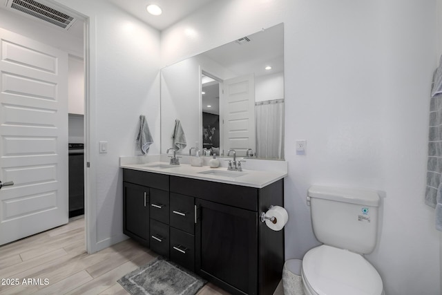 4352 N 91st Gln, Phoenix, AZ 85037 - full bathroom featuring toilet, double vanity, and wood finished floors