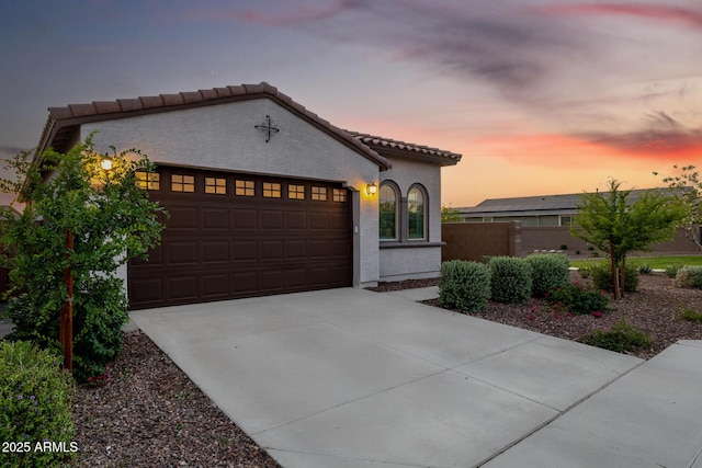 4352 N 91st Gln, Phoenix, AZ 85037 - mediterranean / spanish house with concrete driveway, an attached garage, a tile roof, stucco siding, and fence