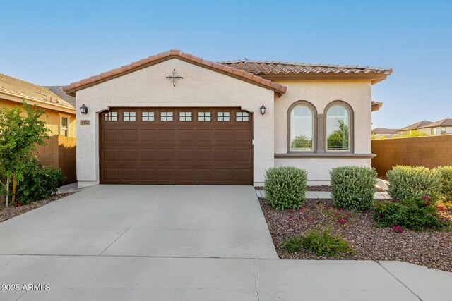 4352 N 91st Gln, Phoenix, AZ 85037 - mediterranean / spanish home with an attached garage, a tiled roof, driveway, stucco siding, and fence