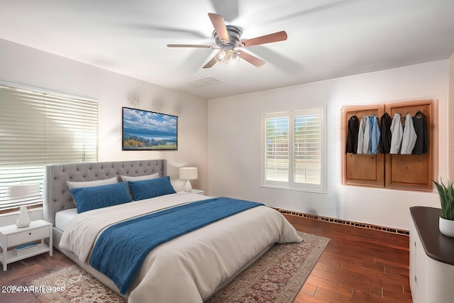 bedroom with hardwood / wood-style flooring, visible vents, and ceiling fan