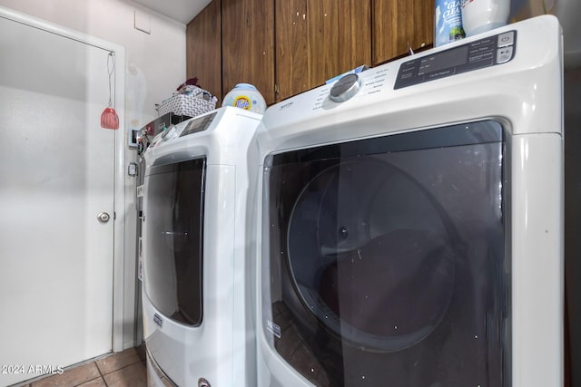 clothes washing area with tile patterned floors, cabinet space, and independent washer and dryer