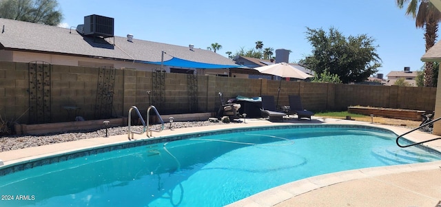 view of pool with a patio area, a fenced in pool, central AC unit, and fence