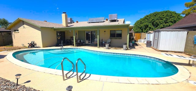 view of pool featuring a fenced in pool, fence, a storage shed, an outdoor structure, and a patio