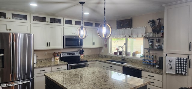 kitchen featuring a kitchen island, a sink, stainless steel appliances, glass insert cabinets, and white cabinetry