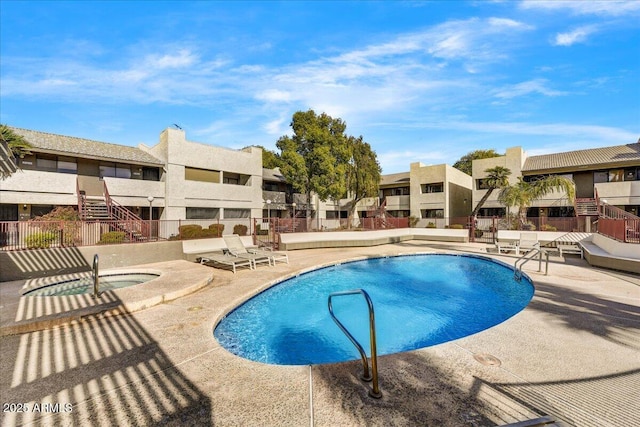 view of swimming pool featuring a hot tub and a patio