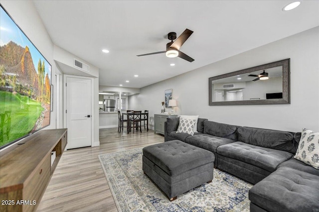 living room with light hardwood / wood-style floors and ceiling fan