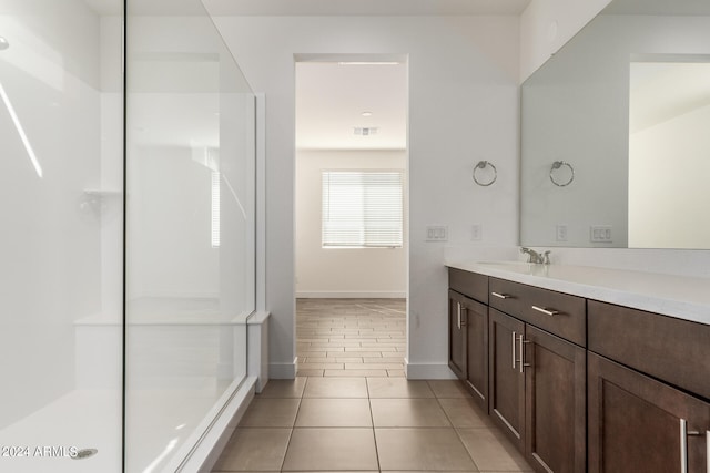 bathroom featuring tile flooring, vanity, and a shower with shower door