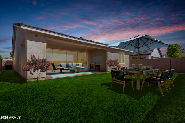 back house at dusk with central air condition unit, outdoor lounge area, a yard, and a patio area