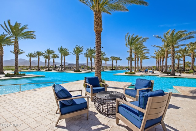 view of swimming pool featuring a patio area and a mountain view