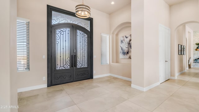 9864 E Baseline Ave, Gold Canyon, AZ 85118 - foyer entrance with french doors, healthy amount of natural light, arched walkways, and light tile patterned flooring