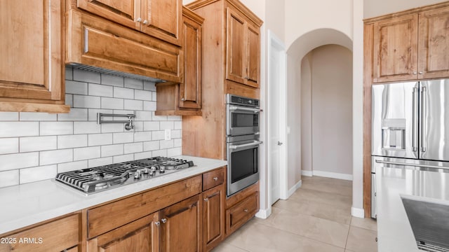 9864 E Baseline Ave, Gold Canyon, AZ 85118 - kitchen featuring stainless steel appliances, tasteful backsplash, light countertops, and arched walkways