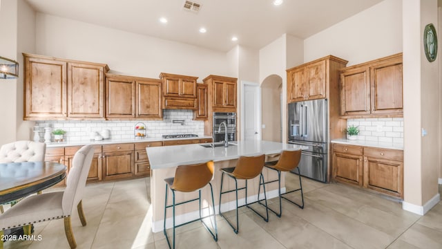 9864 E Baseline Ave, Gold Canyon, AZ 85118 - kitchen featuring stainless steel appliances, light countertops, tasteful backsplash, an island with sink, and a breakfast bar area