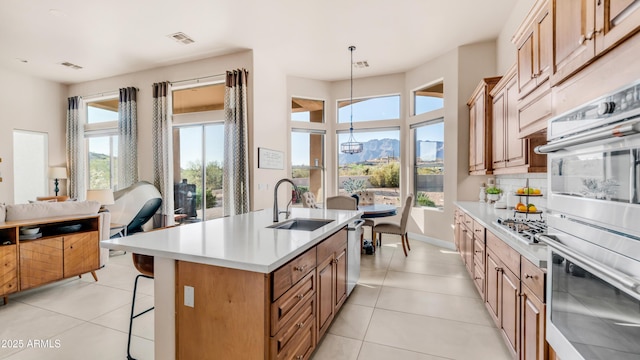 9864 E Baseline Ave, Gold Canyon, AZ 85118 - kitchen with light countertops, light tile patterned floors, a kitchen bar, and a center island with sink