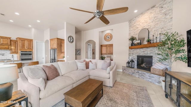 9864 E Baseline Ave, Gold Canyon, AZ 85118 - living area with arched walkways, a ceiling fan, light tile patterned floors, a fireplace, and recessed lighting