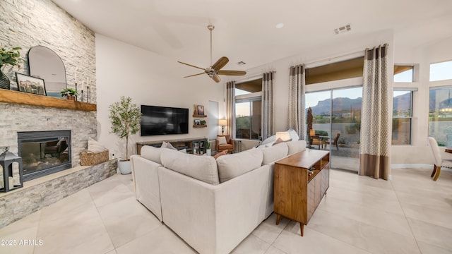 9864 E Baseline Ave, Gold Canyon, AZ 85118 - living room with ceiling fan, a stone fireplace, and light tile patterned floors