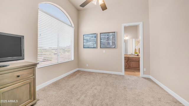9864 E Baseline Ave, Gold Canyon, AZ 85118 - unfurnished bedroom featuring light carpet, multiple windows, ensuite bath, and a ceiling fan