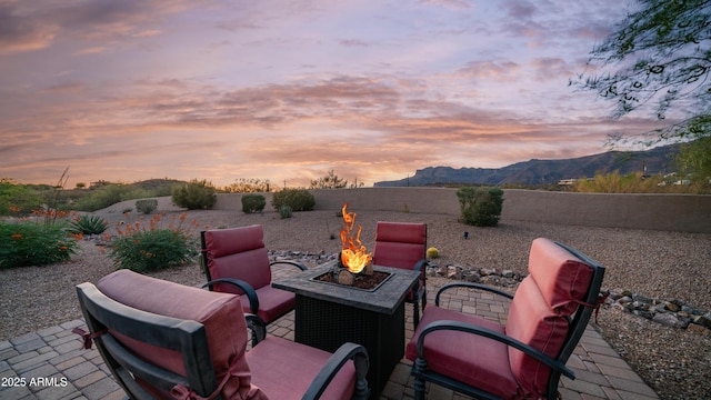 9864 E Baseline Ave, Gold Canyon, AZ 85118 - patio terrace at dusk featuring a mountain view, an outdoor fire pit, a fenced backyard, and a patio area