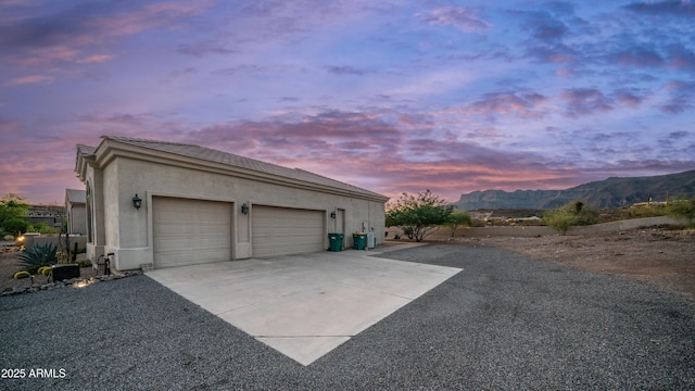 9864 E Baseline Ave, Gold Canyon, AZ 85118 - garage at dusk with driveway and a mountain view