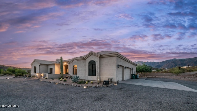 9864 E Baseline Ave, Gold Canyon, AZ 85118 - view of front of home with driveway, an attached garage, stucco siding, and a mountain view