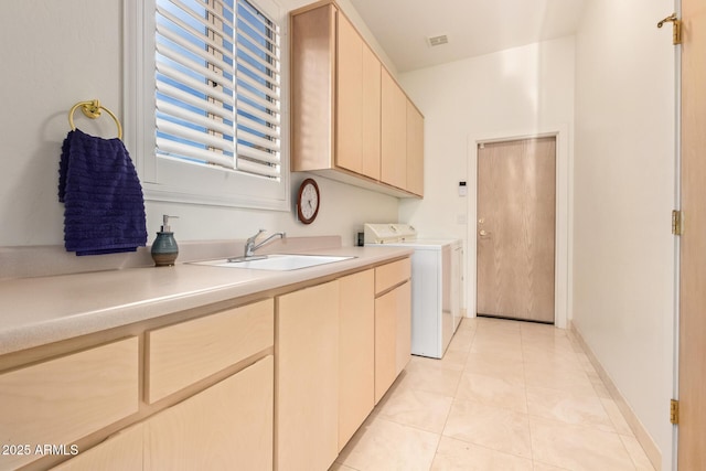 laundry area with washer and dryer, light tile patterned flooring, sink, and cabinets