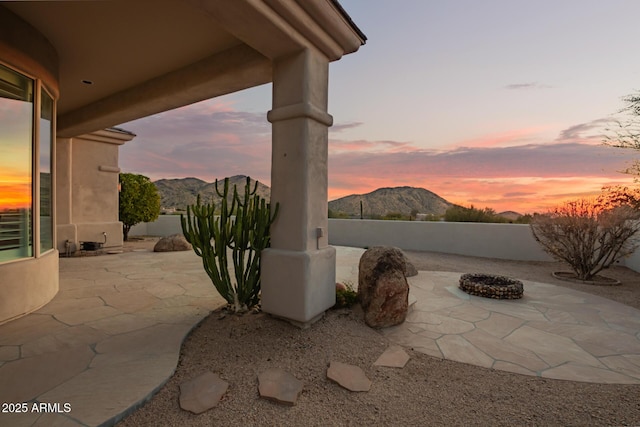 patio terrace at dusk with a mountain view and an outdoor fire pit