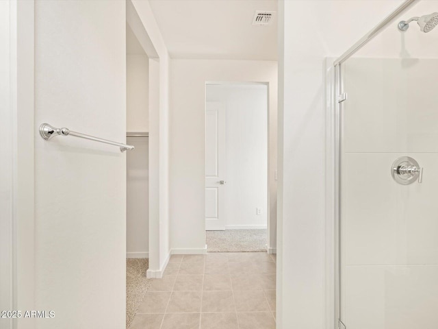 bathroom with an enclosed shower and tile patterned flooring