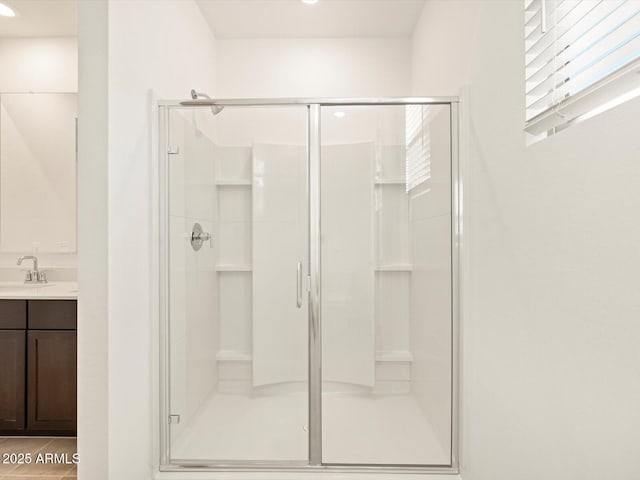 bathroom featuring vanity, a shower with door, and tile patterned floors