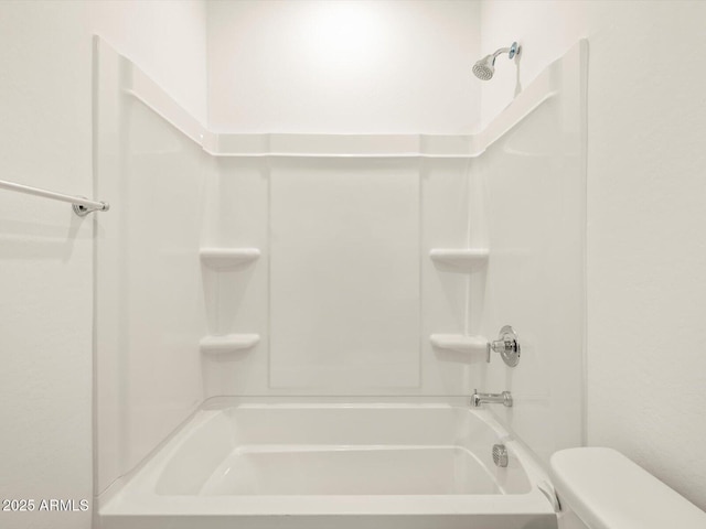 bathroom with bathtub / shower combination and toilet