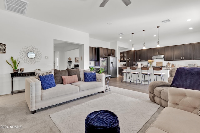 living room featuring ceiling fan and light hardwood / wood-style floors