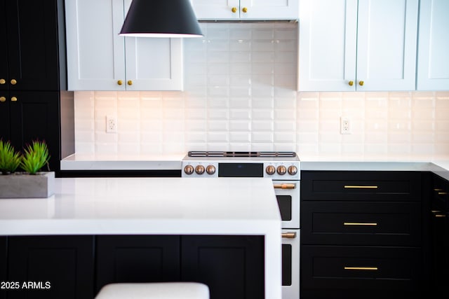 kitchen featuring tasteful backsplash, range with two ovens, and white cabinets