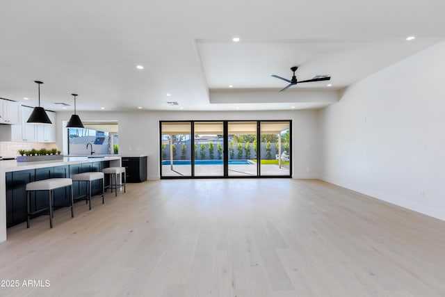 living room featuring sink and light hardwood / wood-style flooring