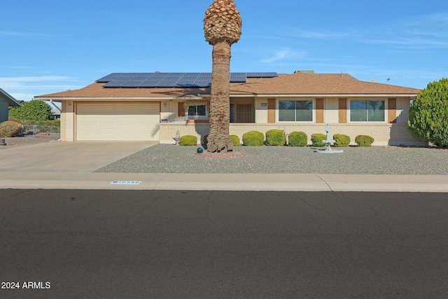 view of front of property featuring solar panels and a garage