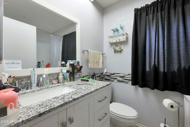 bathroom with vanity, a shower with shower curtain, and toilet