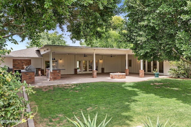 3817 E Highland Ave, Phoenix, AZ 85018 - rear view of house featuring a fire pit, an outdoor kitchen, french doors, and a lawn
